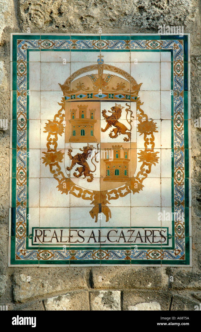 Tile plaque with royal coat of arms of Castile and Leon on the wall of the Reales Alcazares Seville Spain  Stock Photo