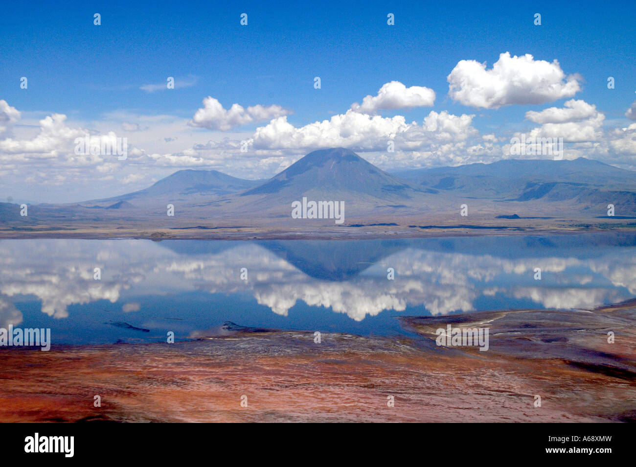 Aerial view of Lake Natron and the volcano Ol Doinyo Lengai, Tanzania. The red pigment in the Cyanobacteria produce a red color. Stock Photo