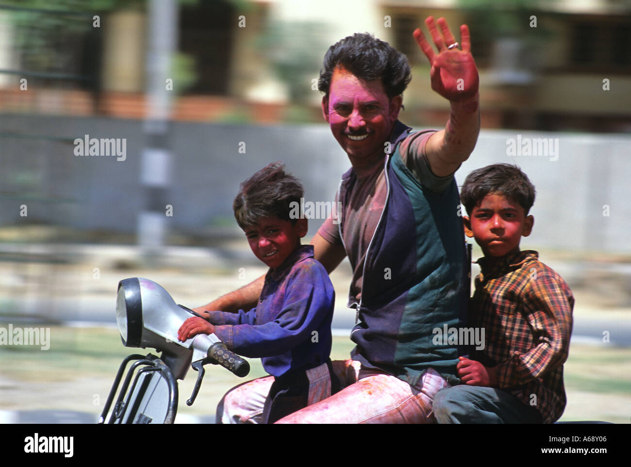 Man rides through Jaipur with his children during Holi festival Stock Photo