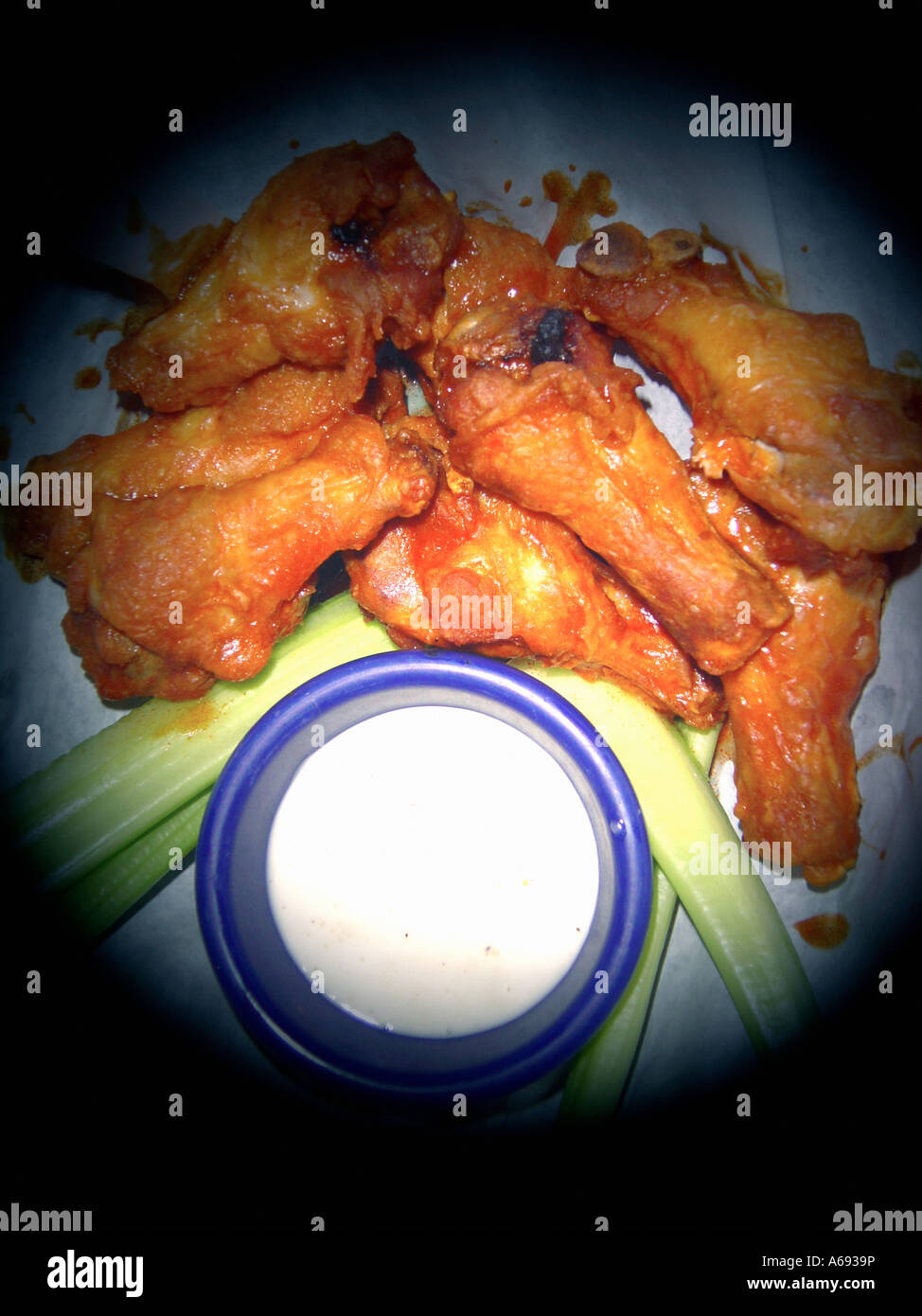 Spot Lit Plate of Hot and Spicy Buffalo Chicken Wings Celery and Bleu Cheese Dressing Viewed From Above Copy Space Stock Photo