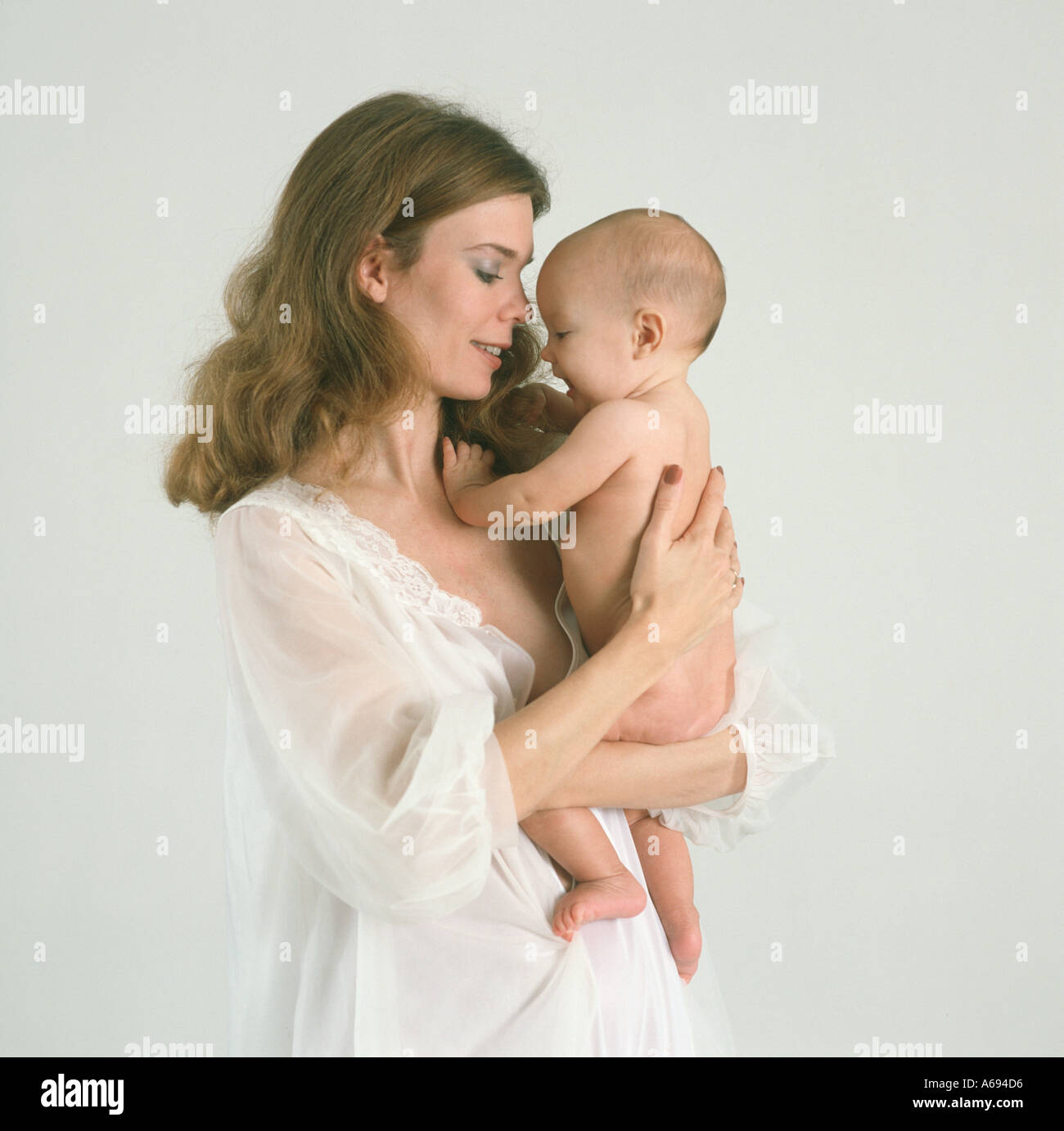 Mother holding baby in bedroom Stock Photo