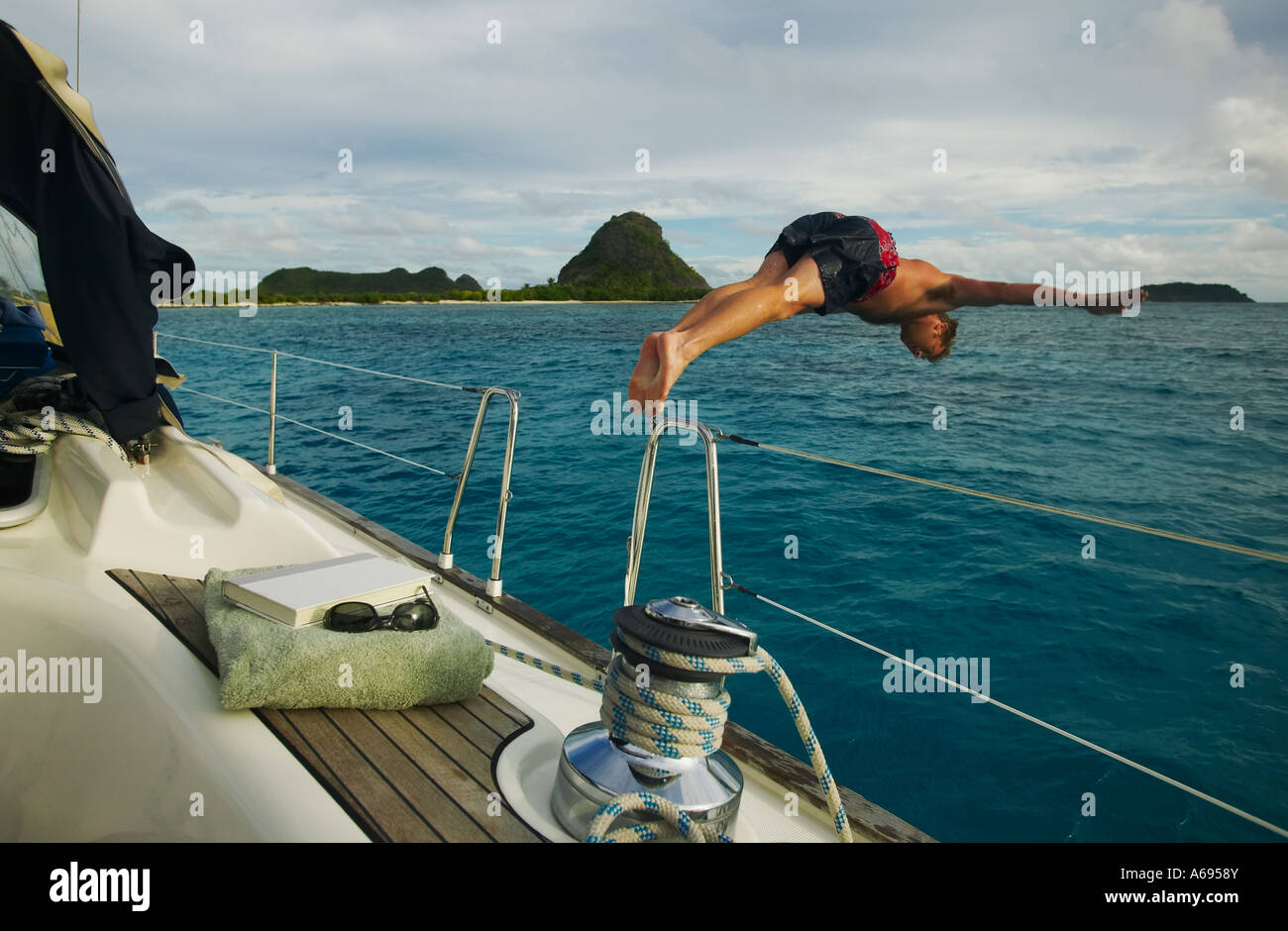 Man diving from sailboat in the Grenadines of the Winward Islands British West Indies Stock Photo