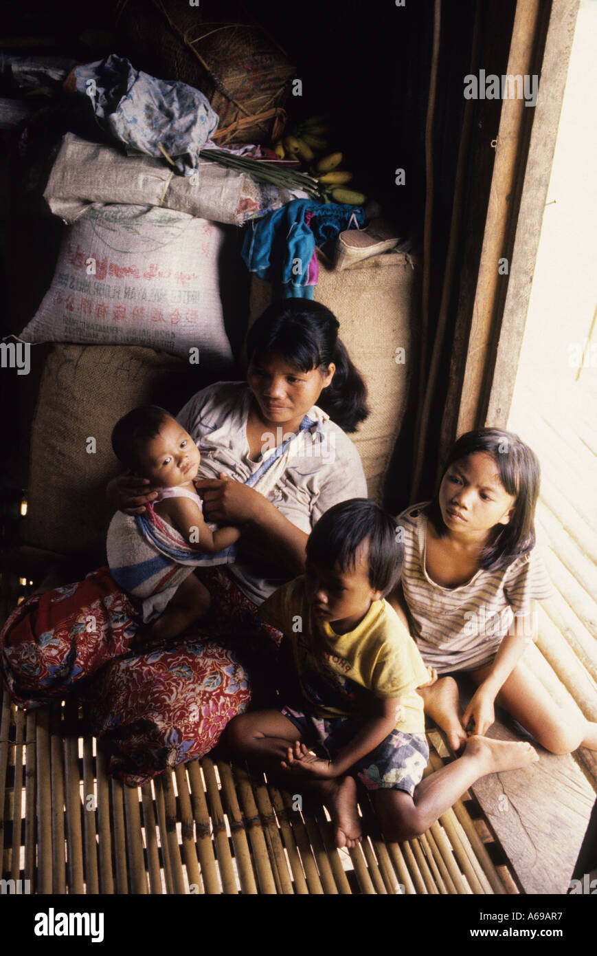 Family sitting inside their long house. ORANG ASLI VILLAGE 