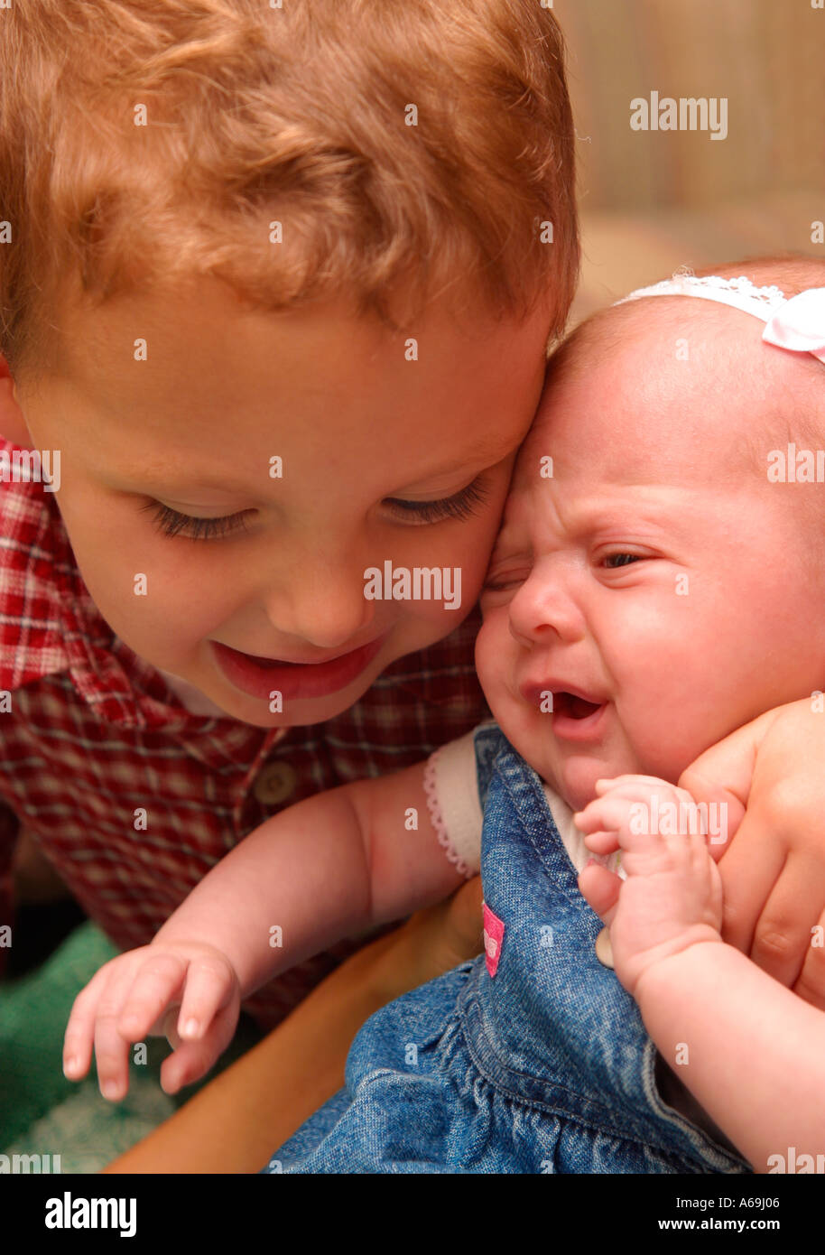 Baby gets a tight hug from big brother Stock Photo - Alamy
