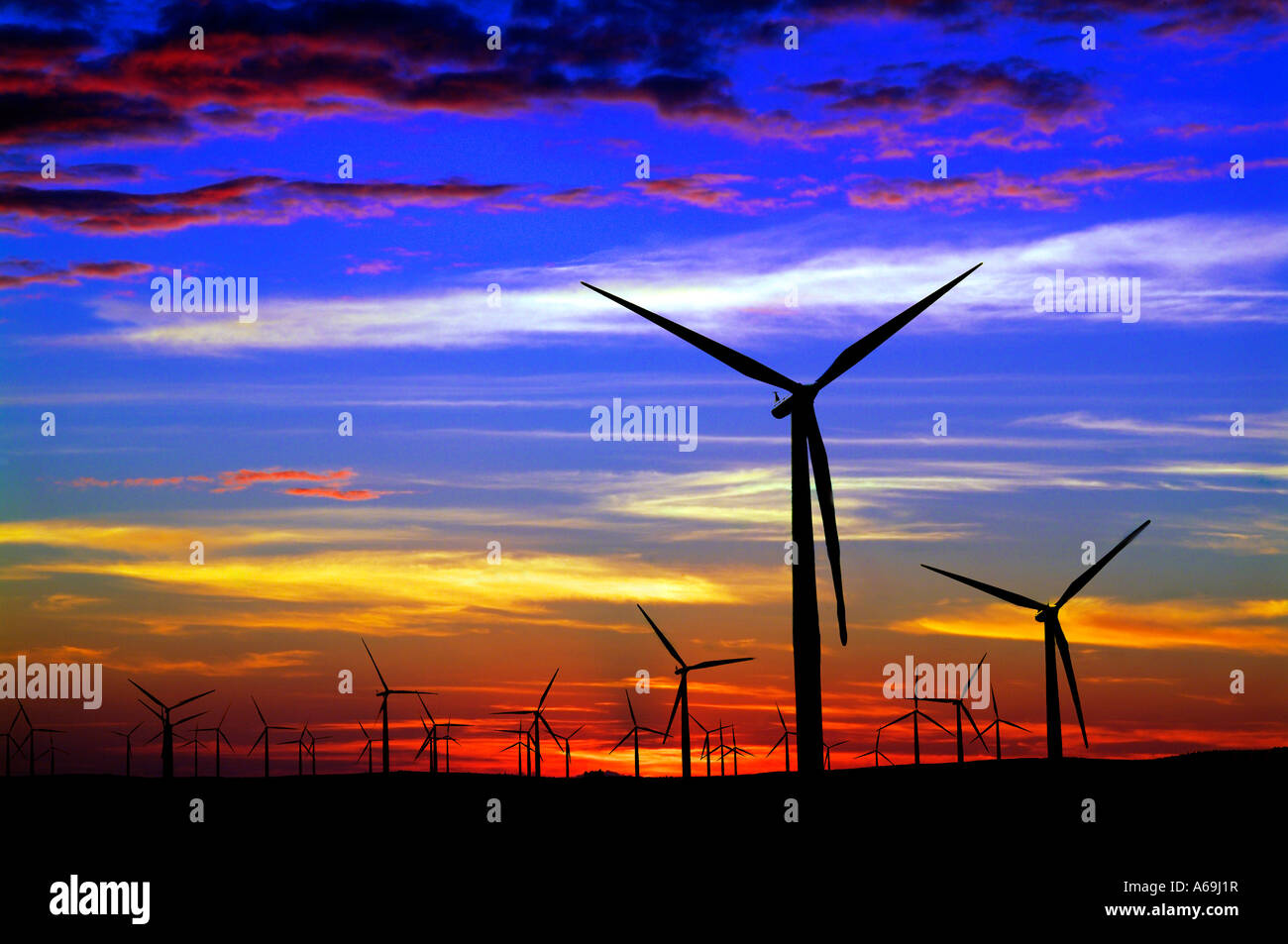 Wind farm silhouetted against colorful sunset sky Stock Photo - Alamy