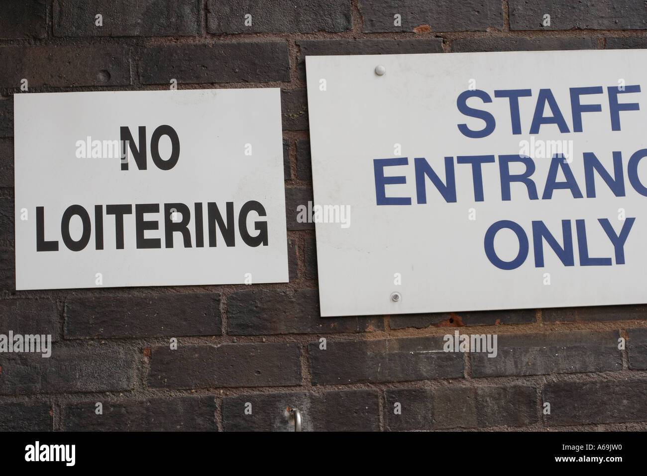 NO LOITERING sign and STAFF ENTRANCE ONLY sign Stock Photo