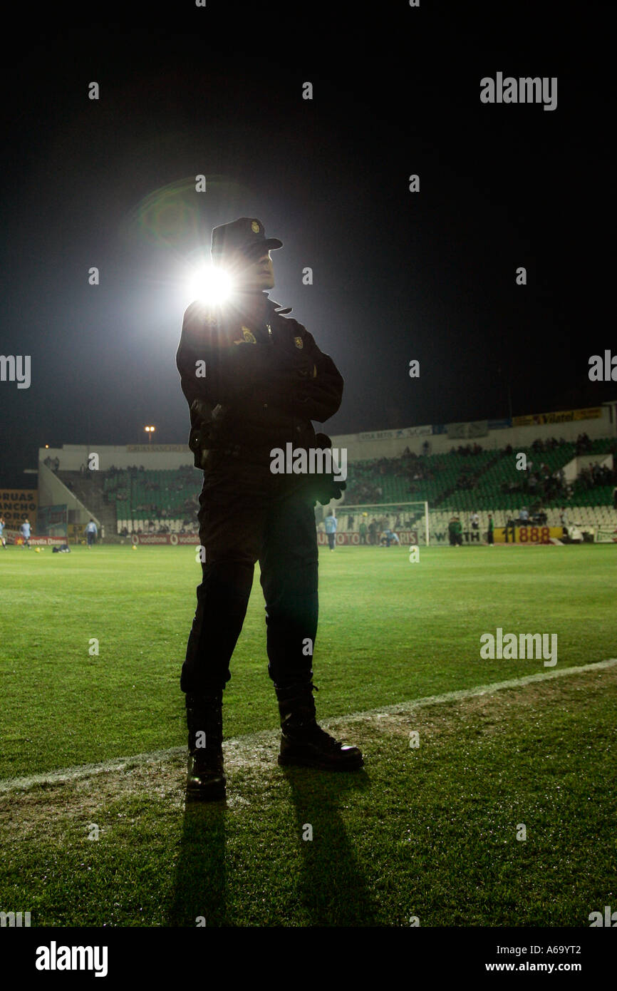 Silhouette of a policeman watching a football game Stock Photo