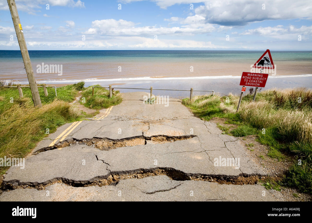 Seaside Road and warning signs in Aldbrough, Yorkshire, UK. Erosion along the North Sea coastline. Stock Photo