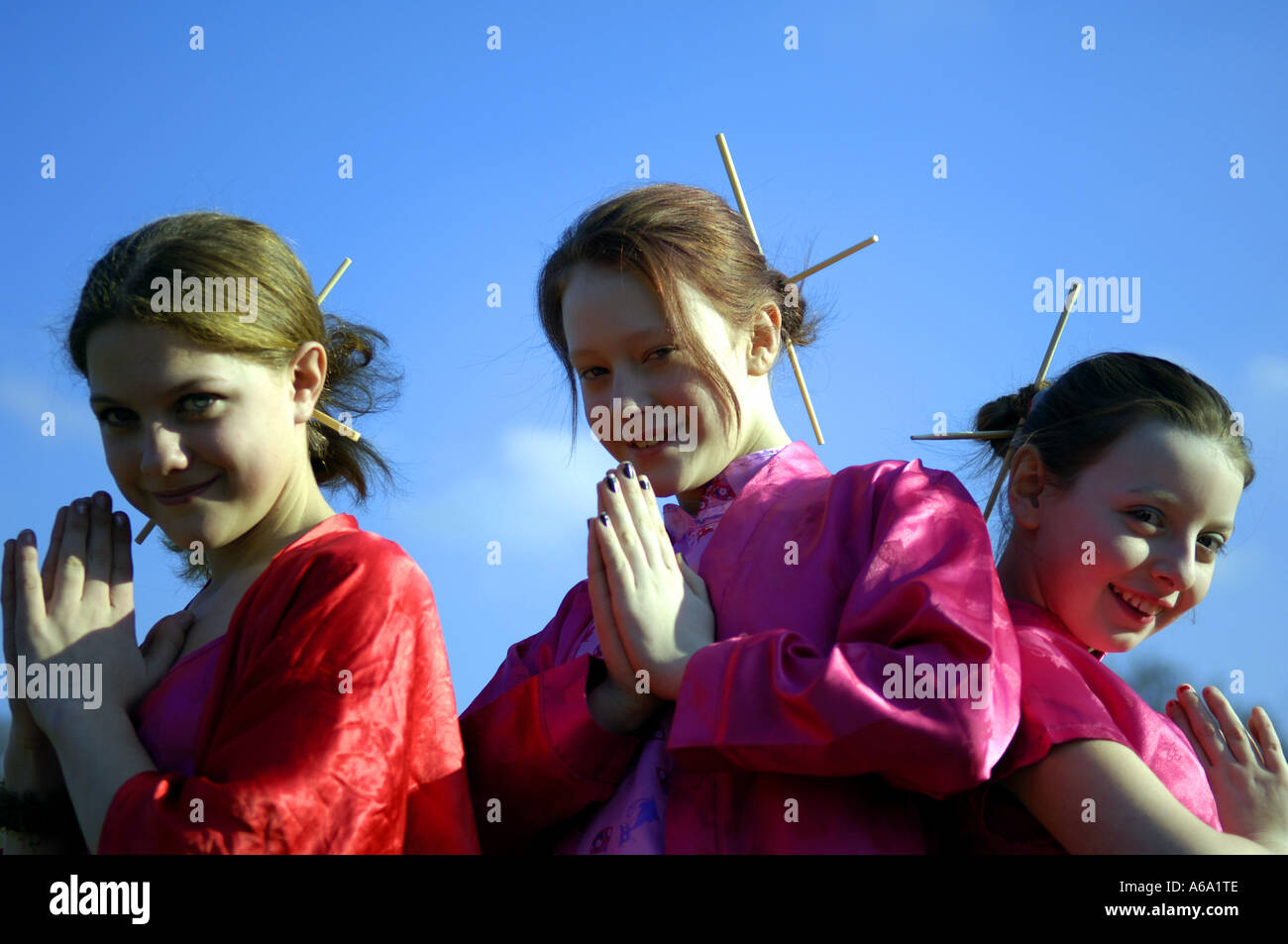 three girls dressed up as miss saigon chopsticks hair fashion eleven years old caucasian white girls female young youth horizont Stock Photo