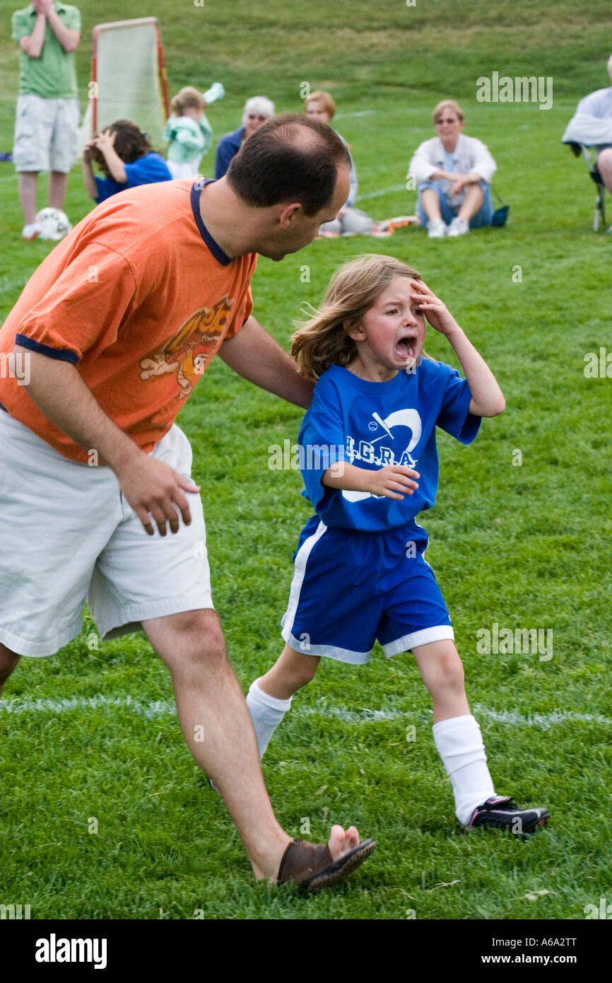 Coach comforting crying soccer player age 35 and 6 after a sports