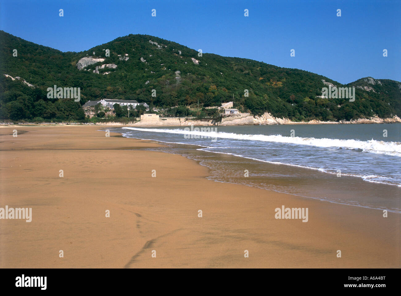 China, Zhejiang, Putuo Shan, Qian Bu Sha (Thousand Step Beach), waves rolling over wet sand of deserted beach Stock Photo