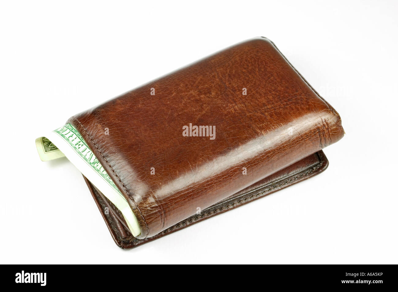 Old brown leather wallet with a dollar bill sticking out isolated on white Stock Photo