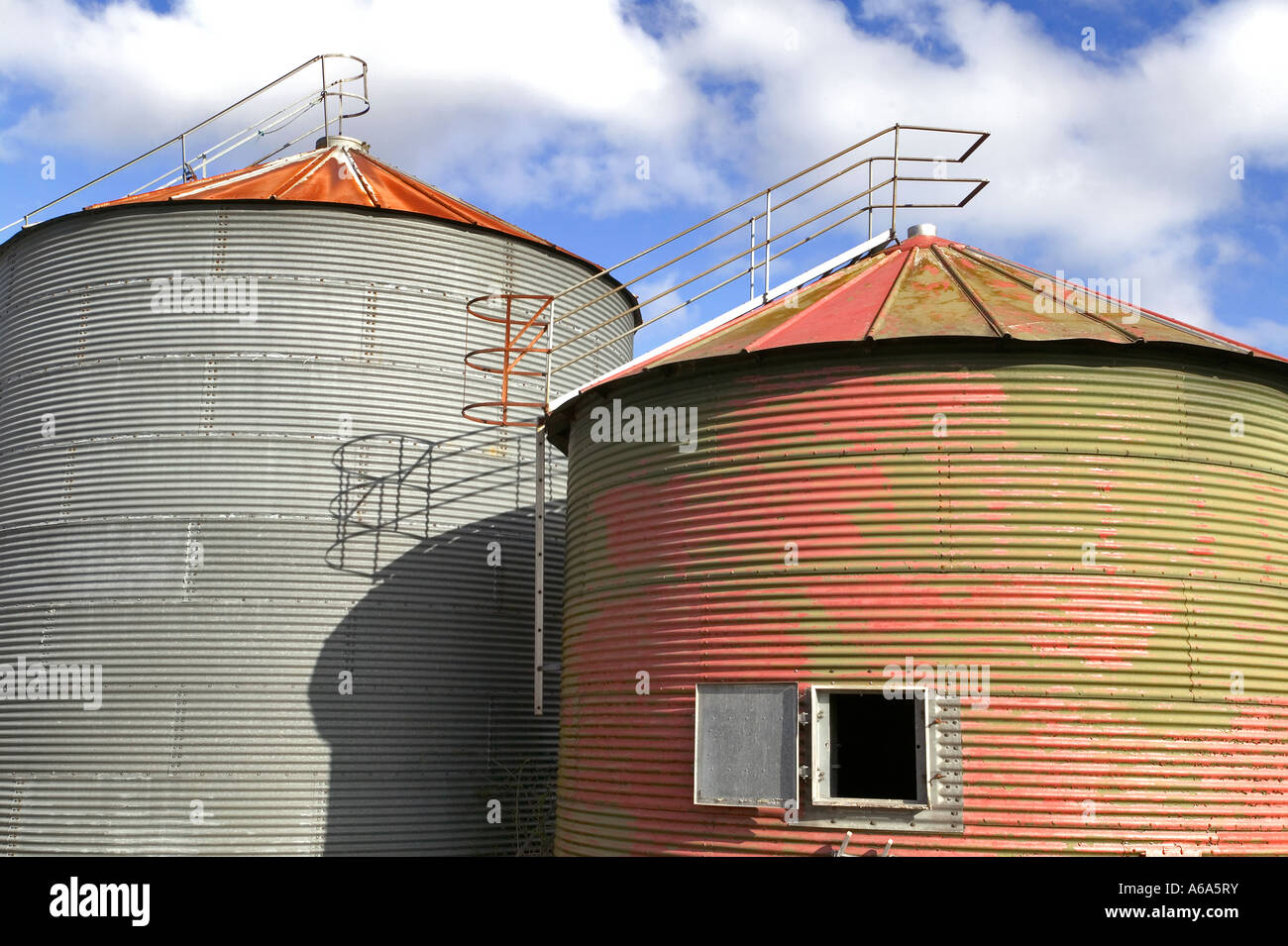 Pair of old grain drying silo s against a blue cloudy sky Stock Photo