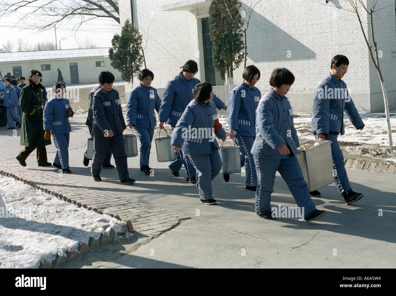 female prisoners carry dining utensils at a prison in Beijing, China . 20-JAN-2000 Stock Photo