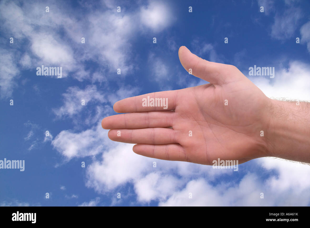Greeting of a handshake against a blue sky Stock Photo