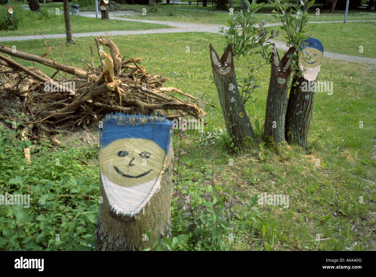 Tree stumps painted with the faces of garden gnomes and rabbits in Germany Stock Photo