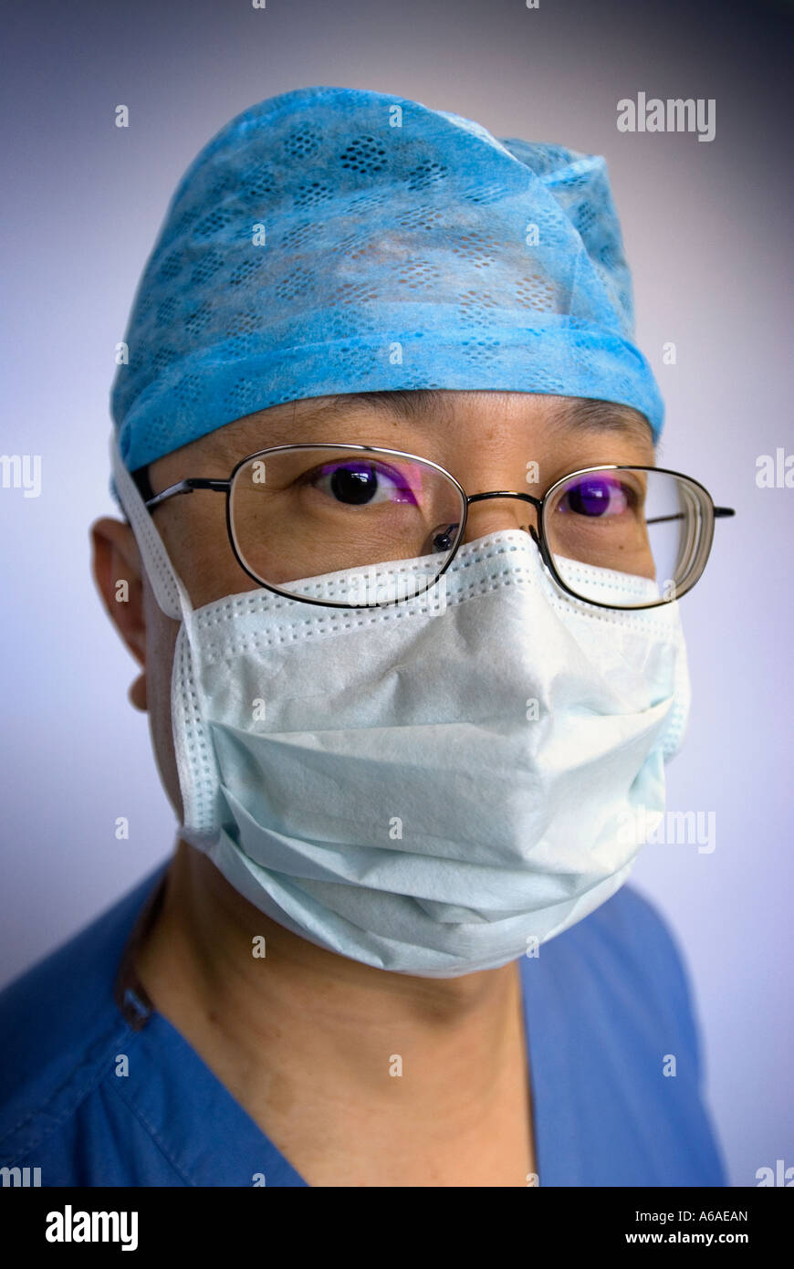 Portrait of a surgeon with his face mask up looking to camera in ...