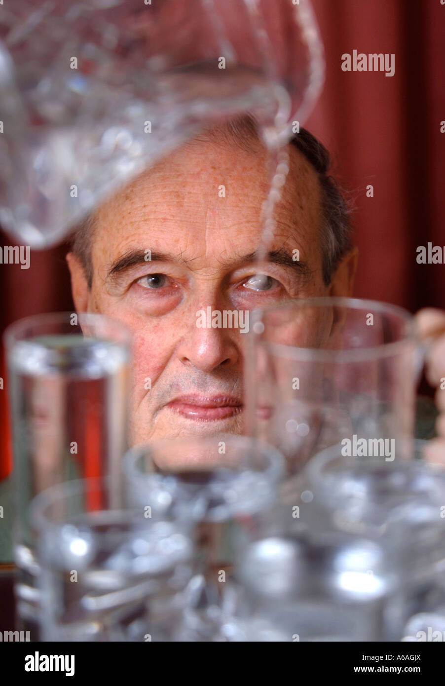 A RETIRED MAN POURING A GLASS OF WATER UK Stock Photo