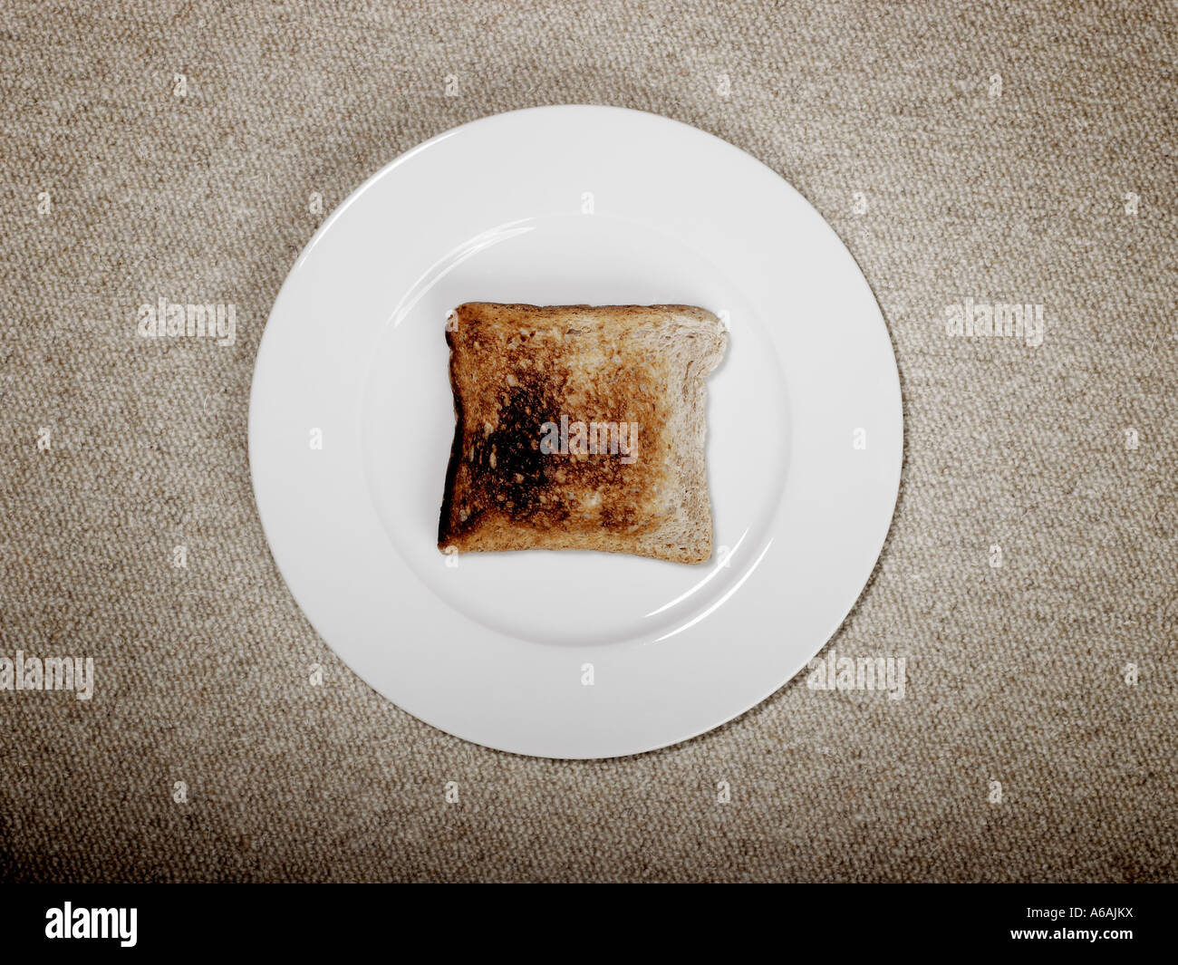 Slice of burnt toast on white plate Stock Photo