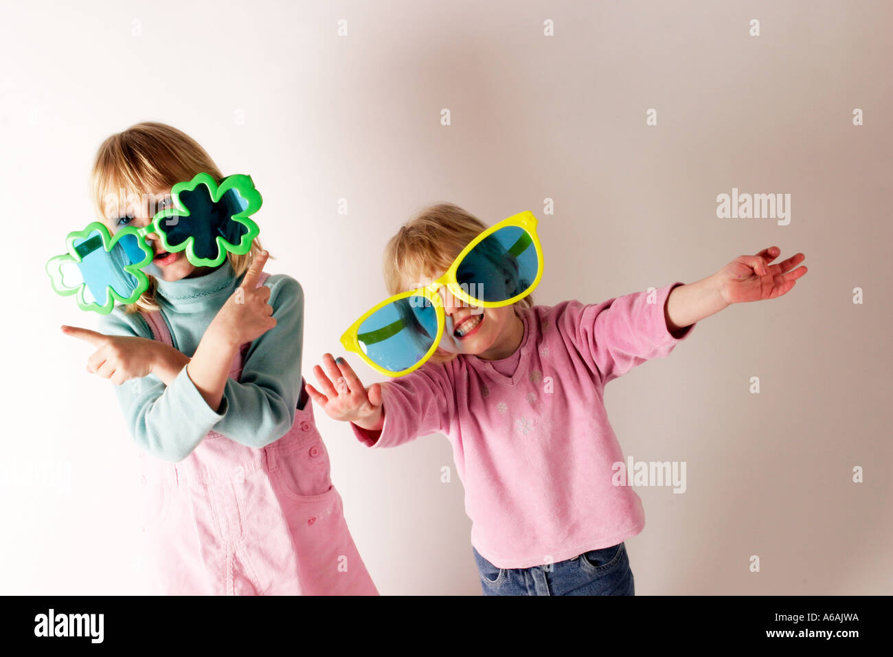 two girls messing about with joke big glasses on children having fun through play Stock Photo Alamy