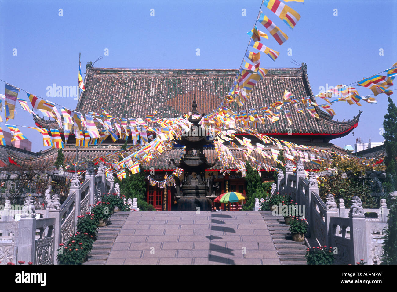 China, Shandong Province, Kaifeng, Da Xiangguo Si prayer flags attached to incense burner at top of steps in front of temple Stock Photo