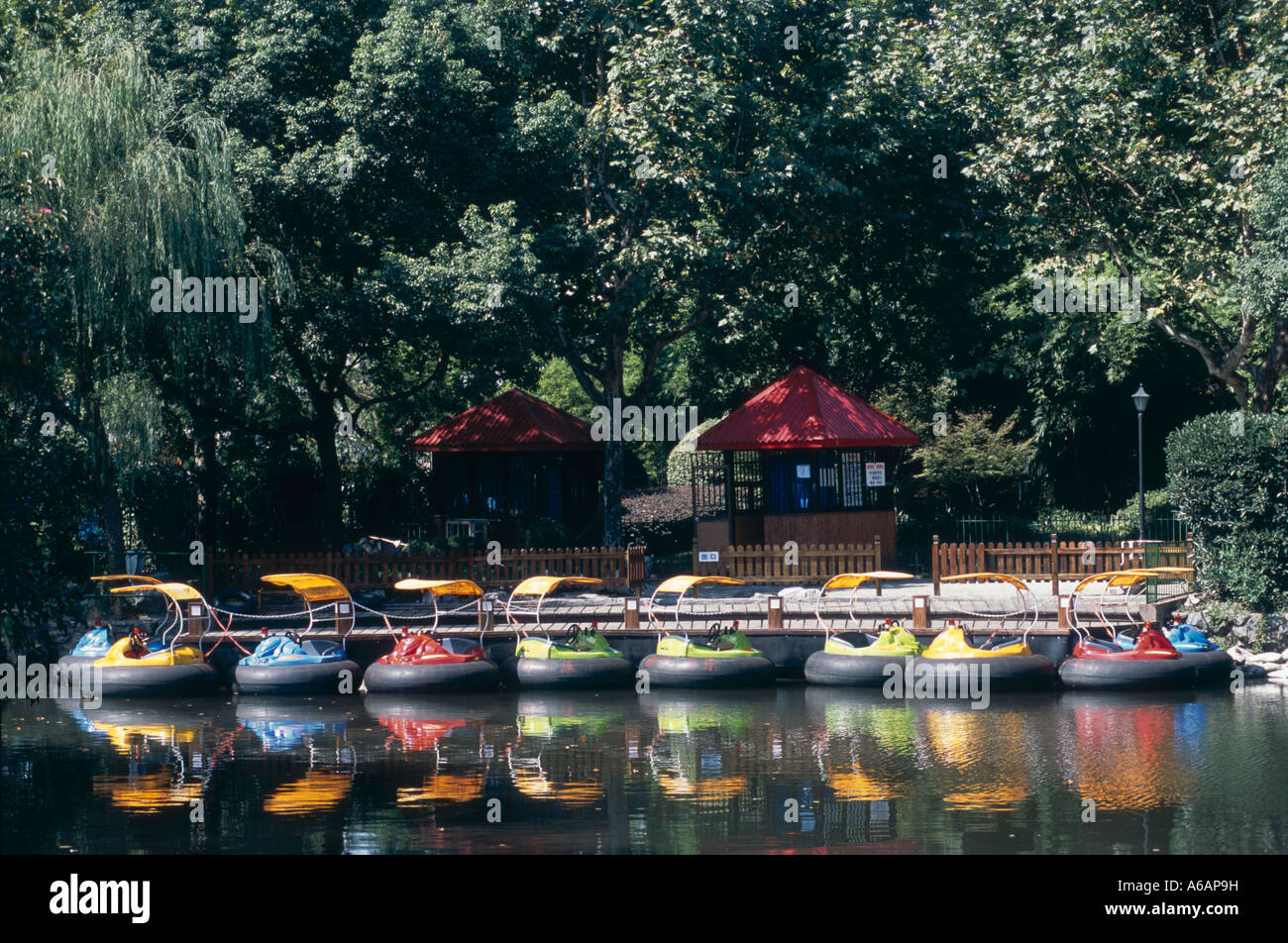 China, Shanghai, Hongkou Park, (Lu Xun Park), brightly colored boats alongside lake pier Stock Photo