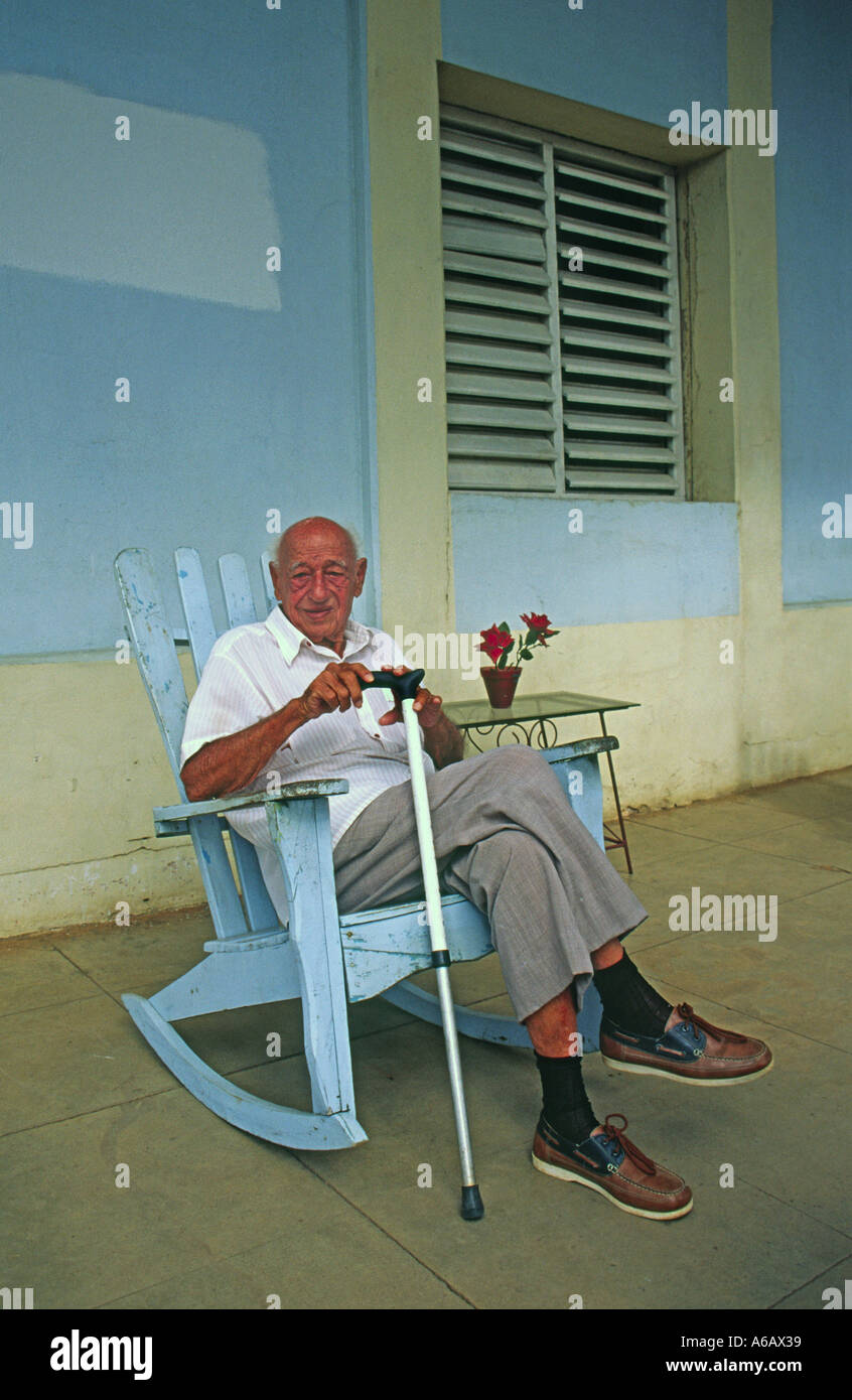 Man sitting in a rocking chair on his front porch in Vinales Cuba Stock