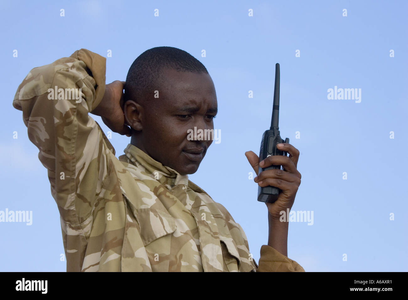 Wildlife ranger on anti poaching patrol communicating with colleague using two way radio Tsavo West National Park Kenya Stock Photo