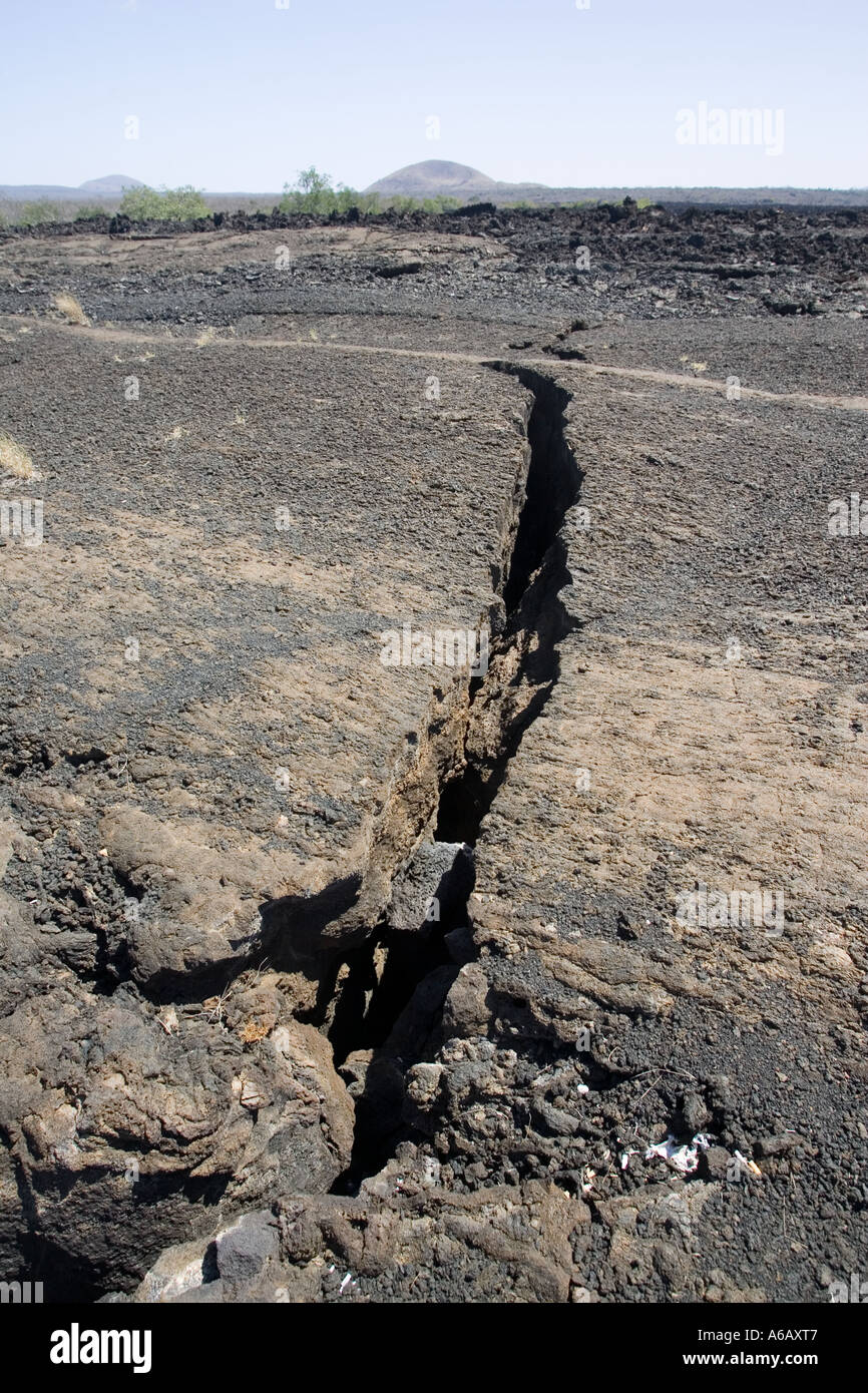 Fissure in Shitani lava flow with volcanic cones of Chyulu Hills Tsavo National Park West Kenya East Africa Stock Photo