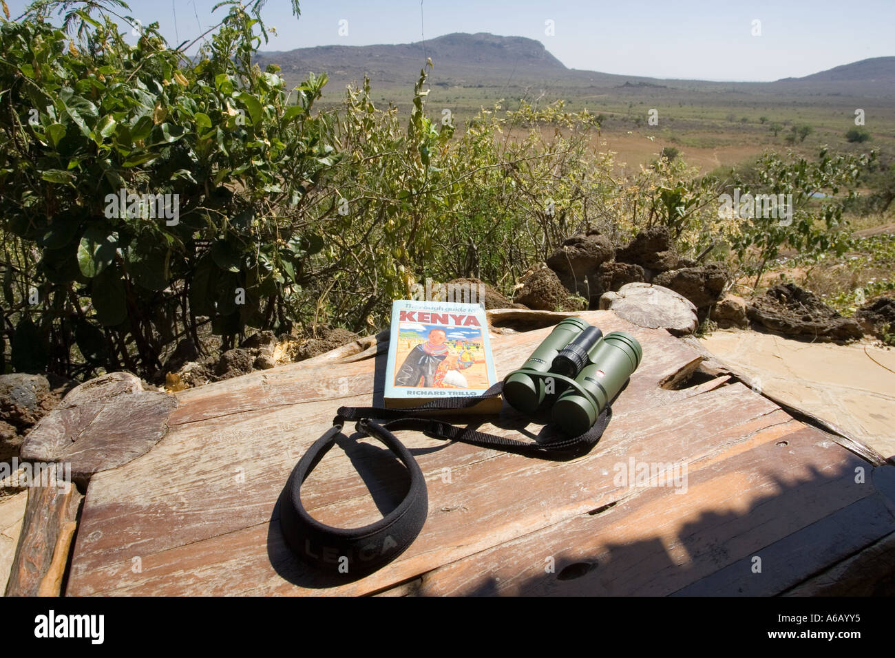 Binoculars and Kenya guide book on table on veranda at Ngulia Bandas in Tsavo National Park West Kenya Stock Photo