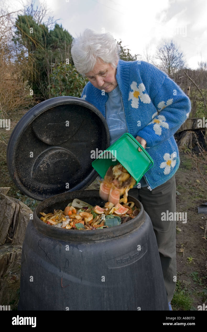 Housewife tipping variety of kitchen waste including vegetable peelings