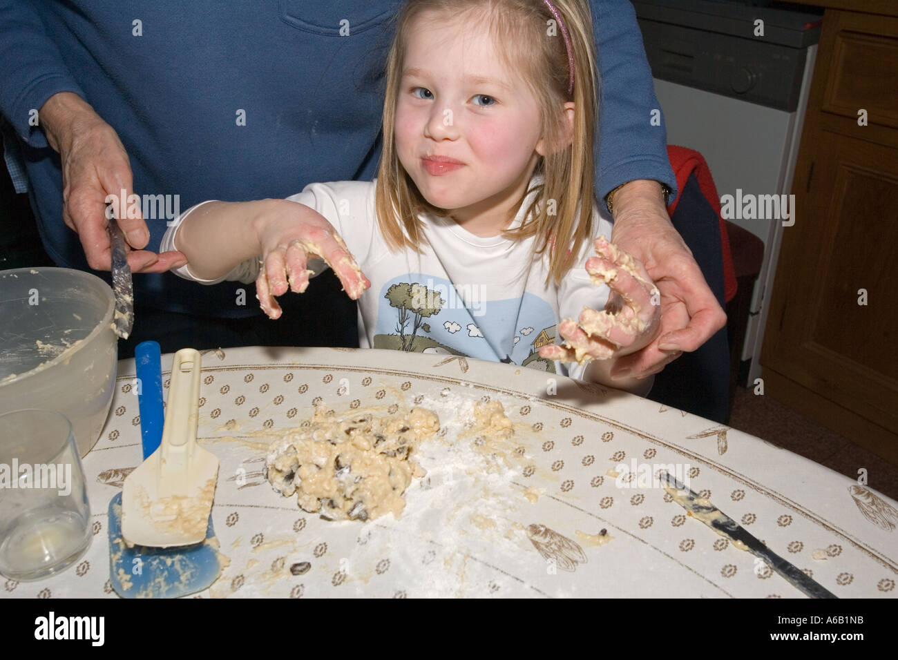 Five year old Faith with sticky fingers mixing dough to make scones on
