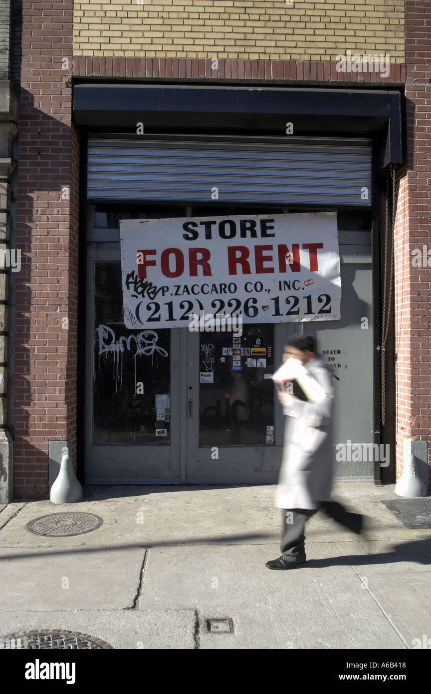 Store display for rent banner sign man walking Stock Photo - Alamy
