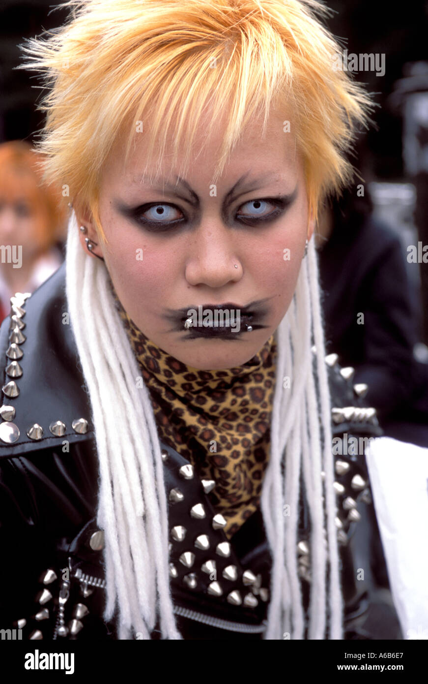 A girl with beady eyes and orange hair stares at the camera during 'cosplay,' or costume play in Harajuku Tokyo Stock Photo