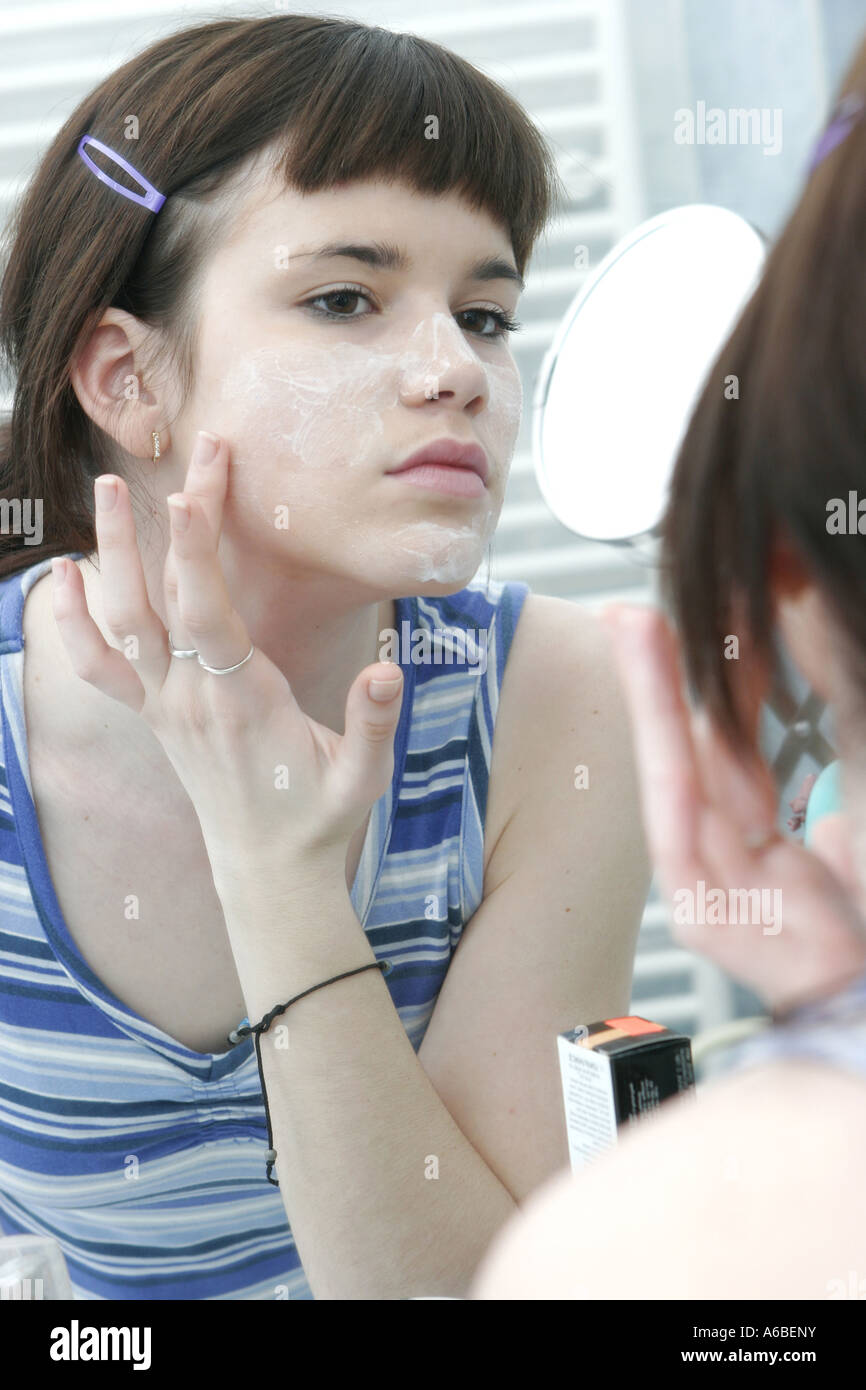 Young woman applying creme on face Stock Photo