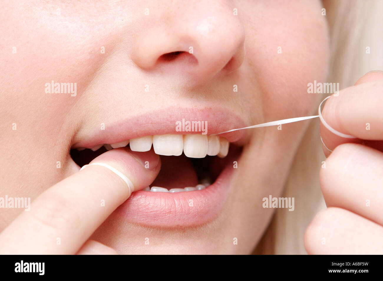woman cleaning teeth with dental floss Stock Photo