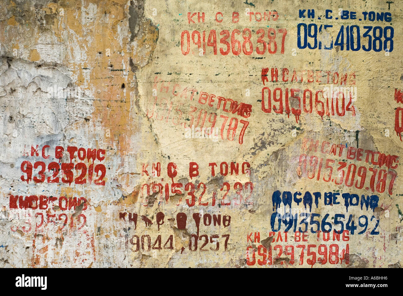 An old wall in Hanoi Vietnam with phone numbers painted on it Stock Photo
