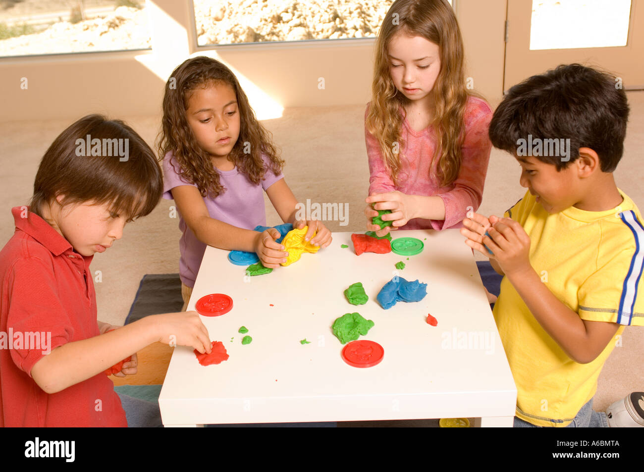 Portrait of children playing with playdough Stock Photo