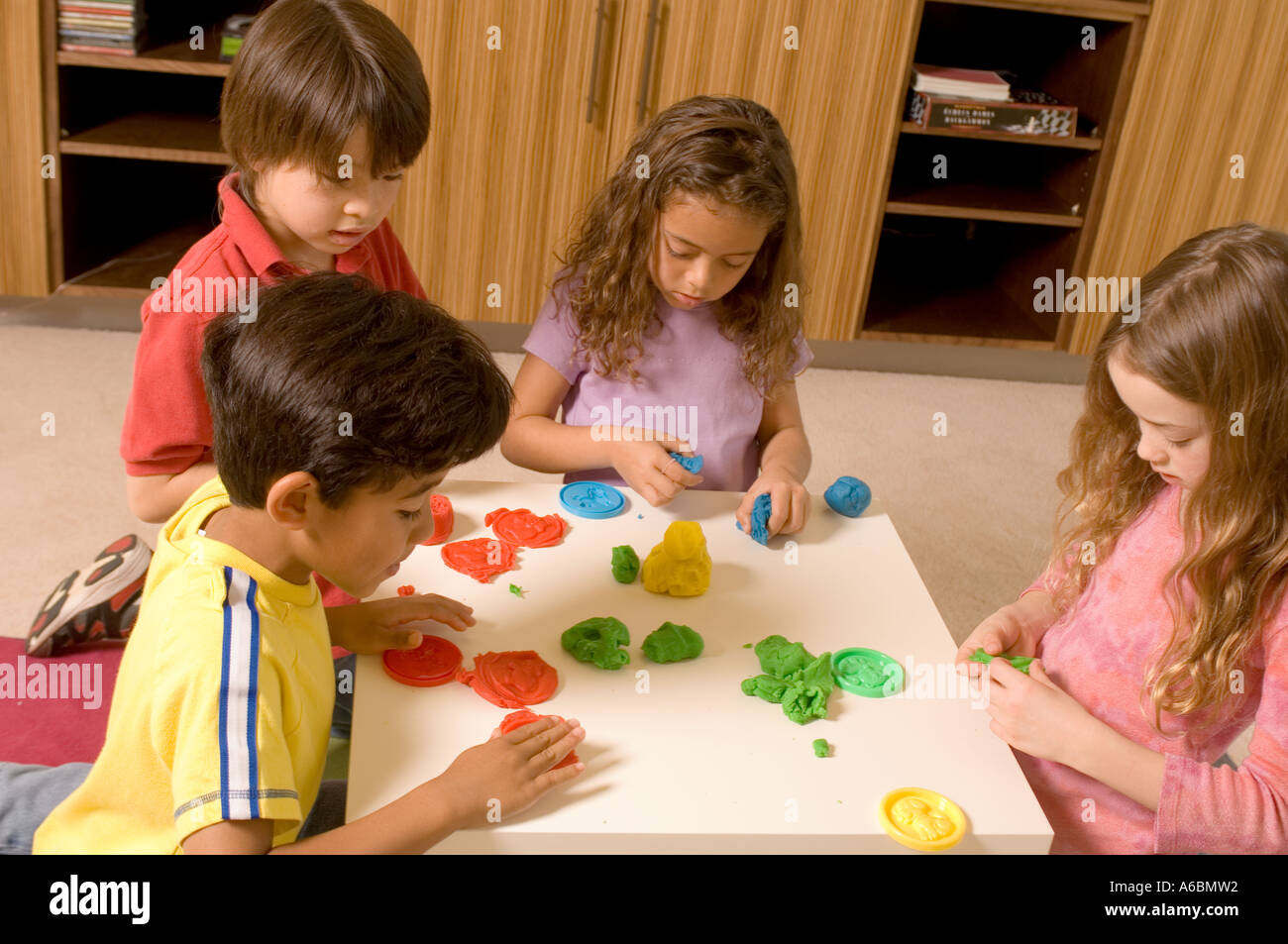 Portrait of children playing with playdough Stock Photo
