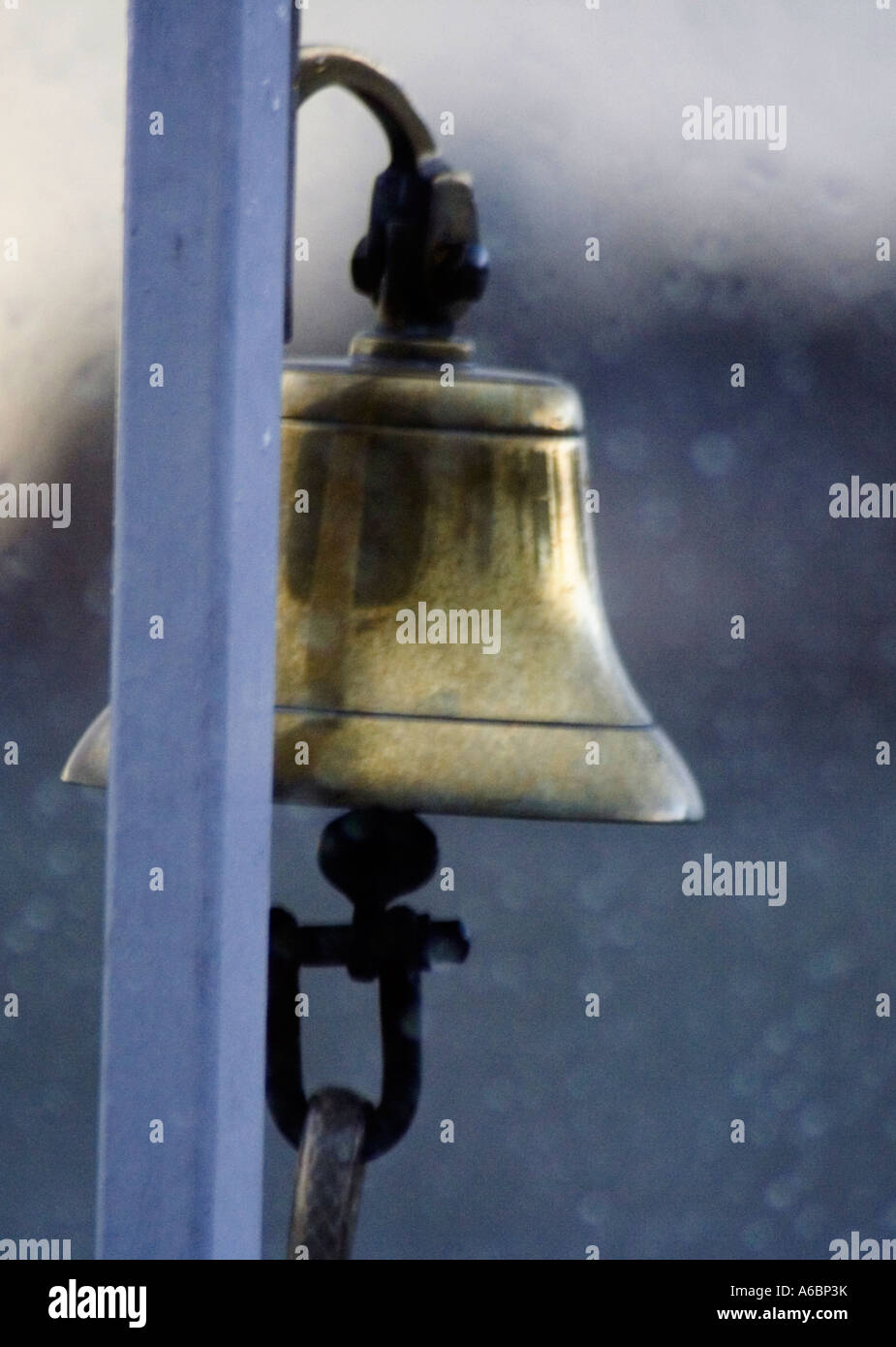 SHIP'S BELL. The bell of a Thames cruise ship, taken in stormy weather, through a window from inside the lower  deck. Stock Photo