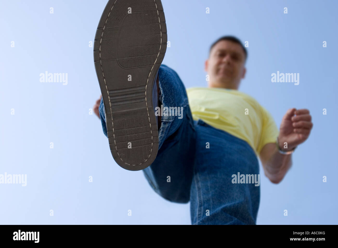 Funny exaggerated image of a man about to squash something with the sole of his large shoe. Stock Photo