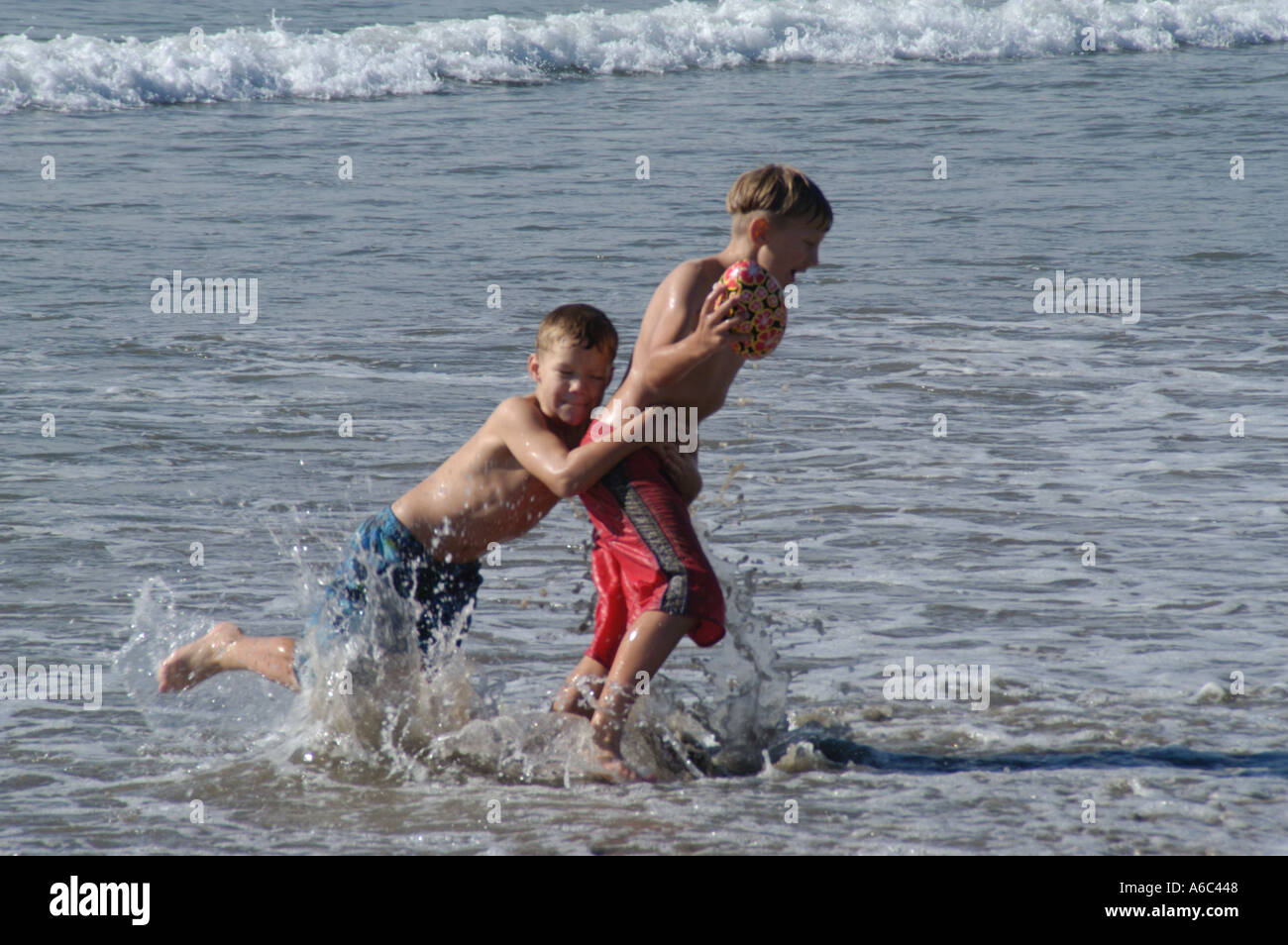 Two young boys playing in the sea Stock Photo - Alamy