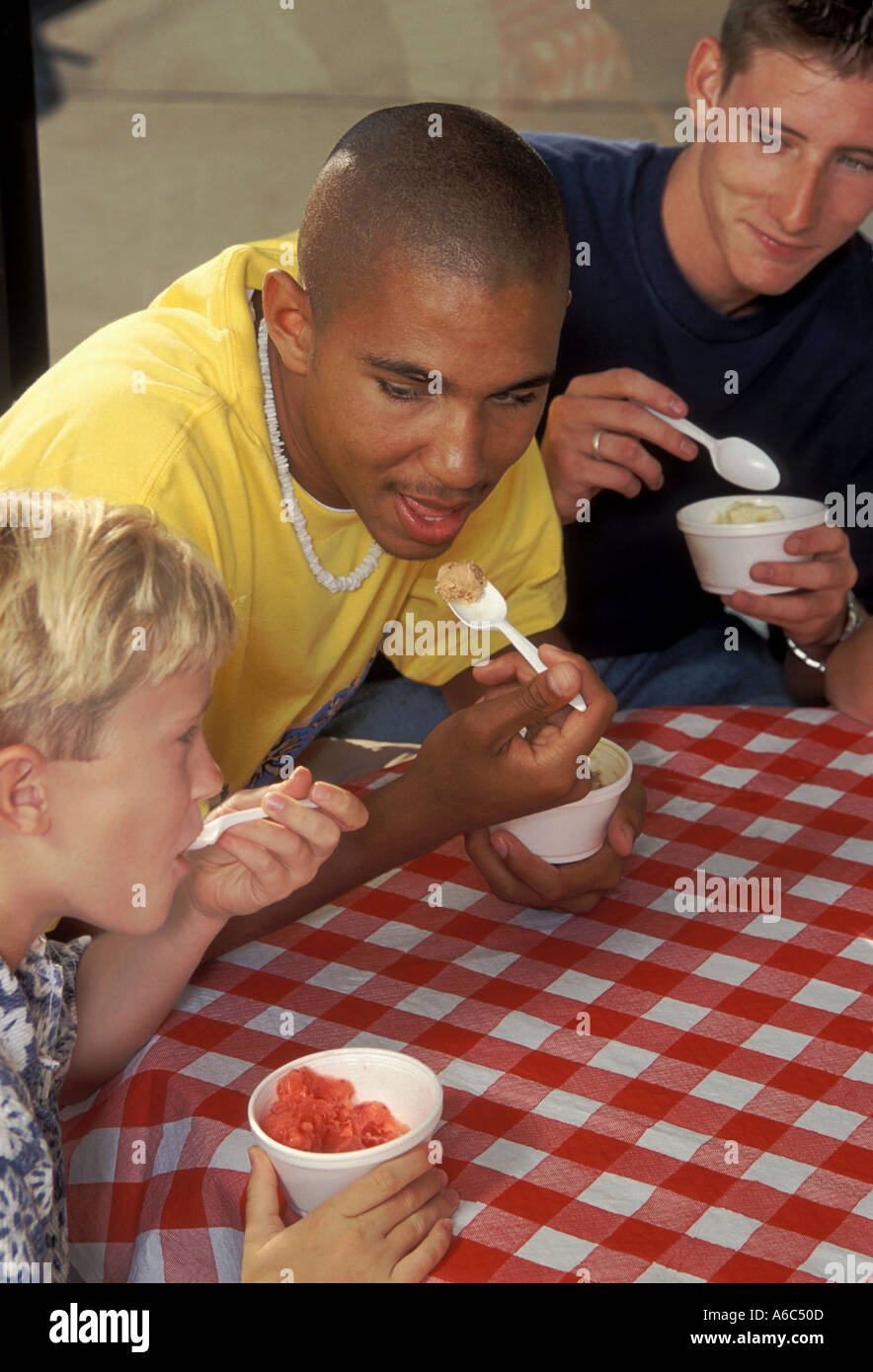 Two mixed ethnic teens and one eight year old boy eat ice cream in