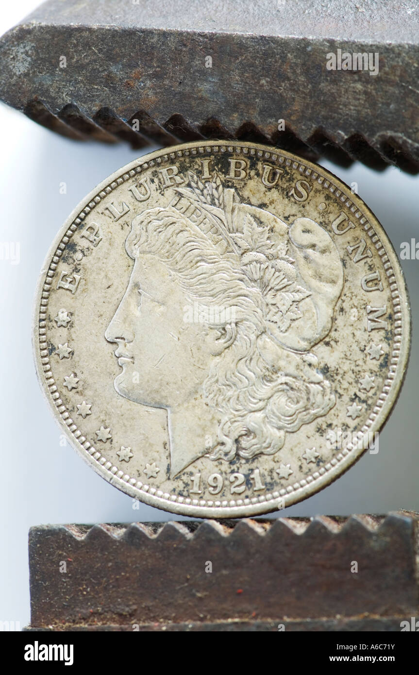 USA silver dollar gripped by steel wrench Stock Photo