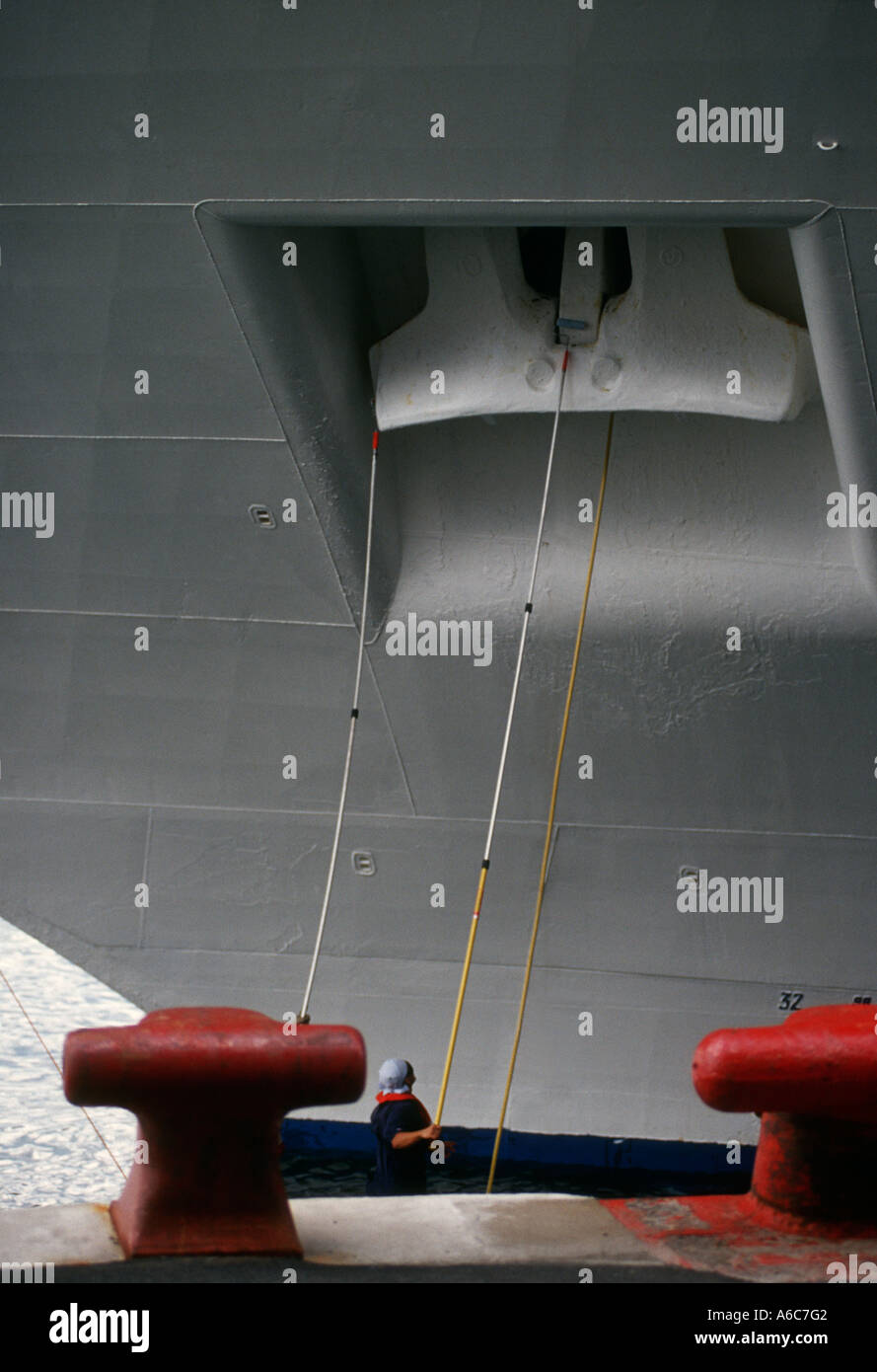Two men cleaning the enormous anchor of a cruise ship in Halifax