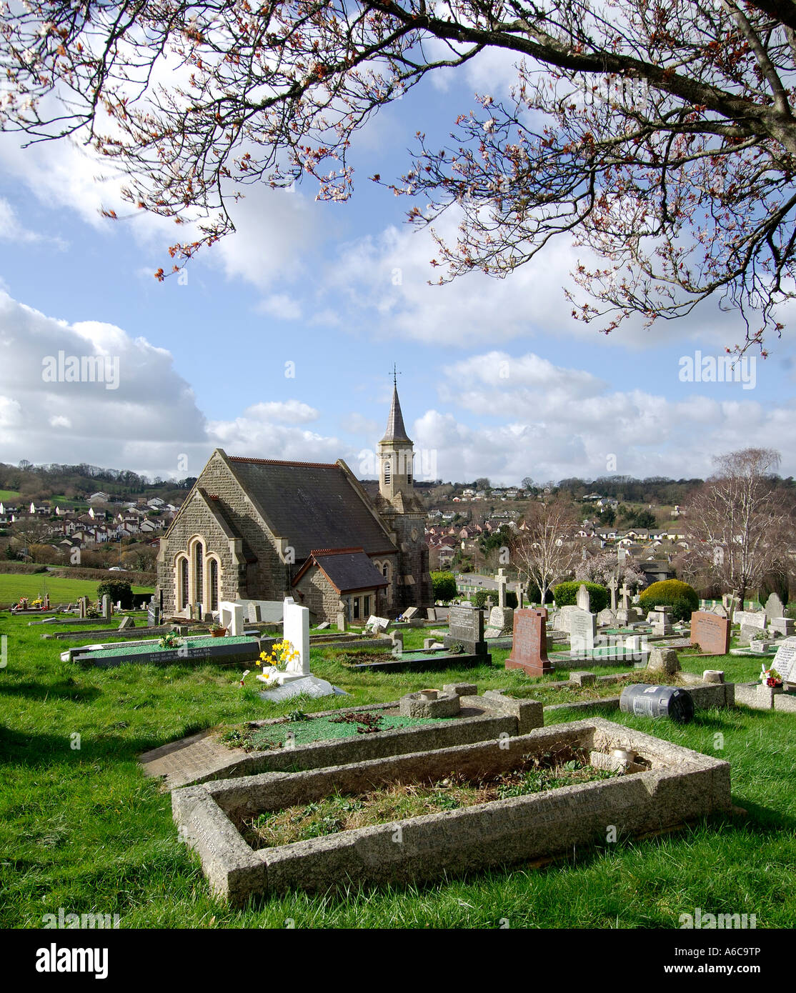 Cemetary and chapel at Ogwell Cross in Newton Abbot South Devon England with overhanging tree branches blurred by the wind Stock Photo