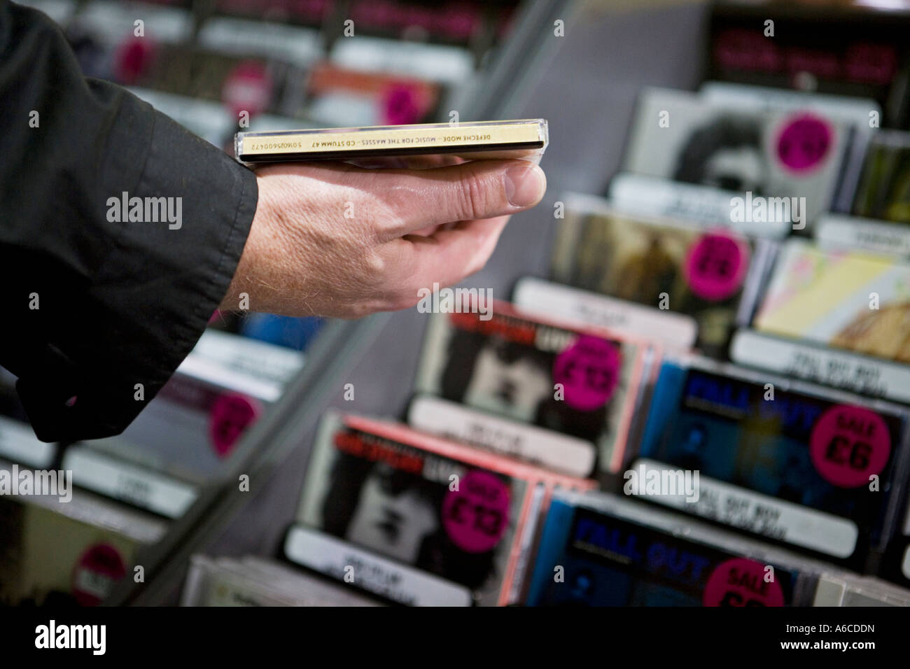 Man picks up CD off shelf in HMV at Piccadilly Circus CD sales are dropping as online music downloads increase Stock Photo