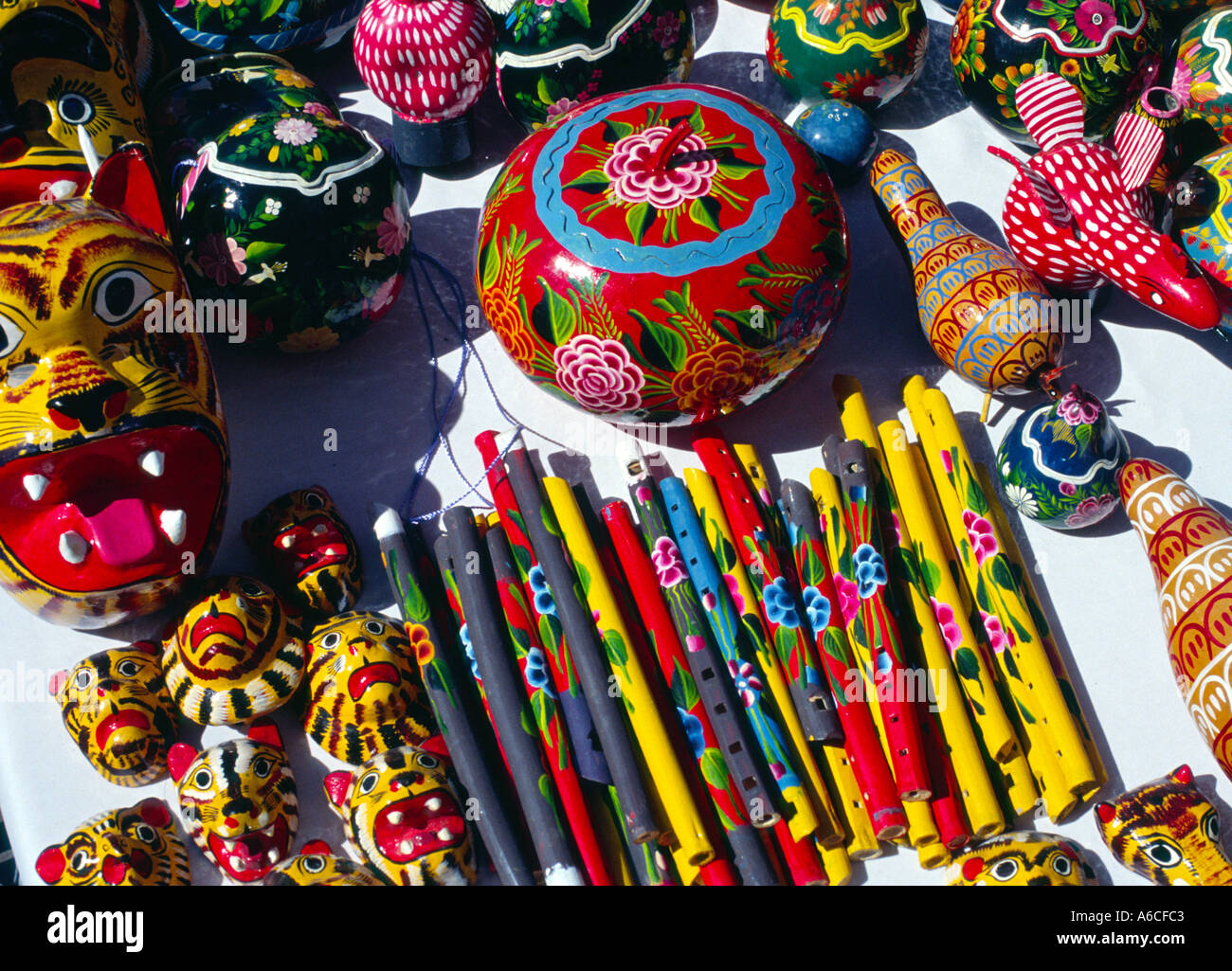 Brightly painted and lacquered gourds and whistles and wooden boxes on a craft stall Mexico Stock Photo