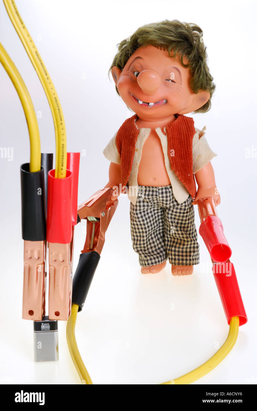 Mad doll manikin connected to a battery by jumper cables for thrills Stock Photo
