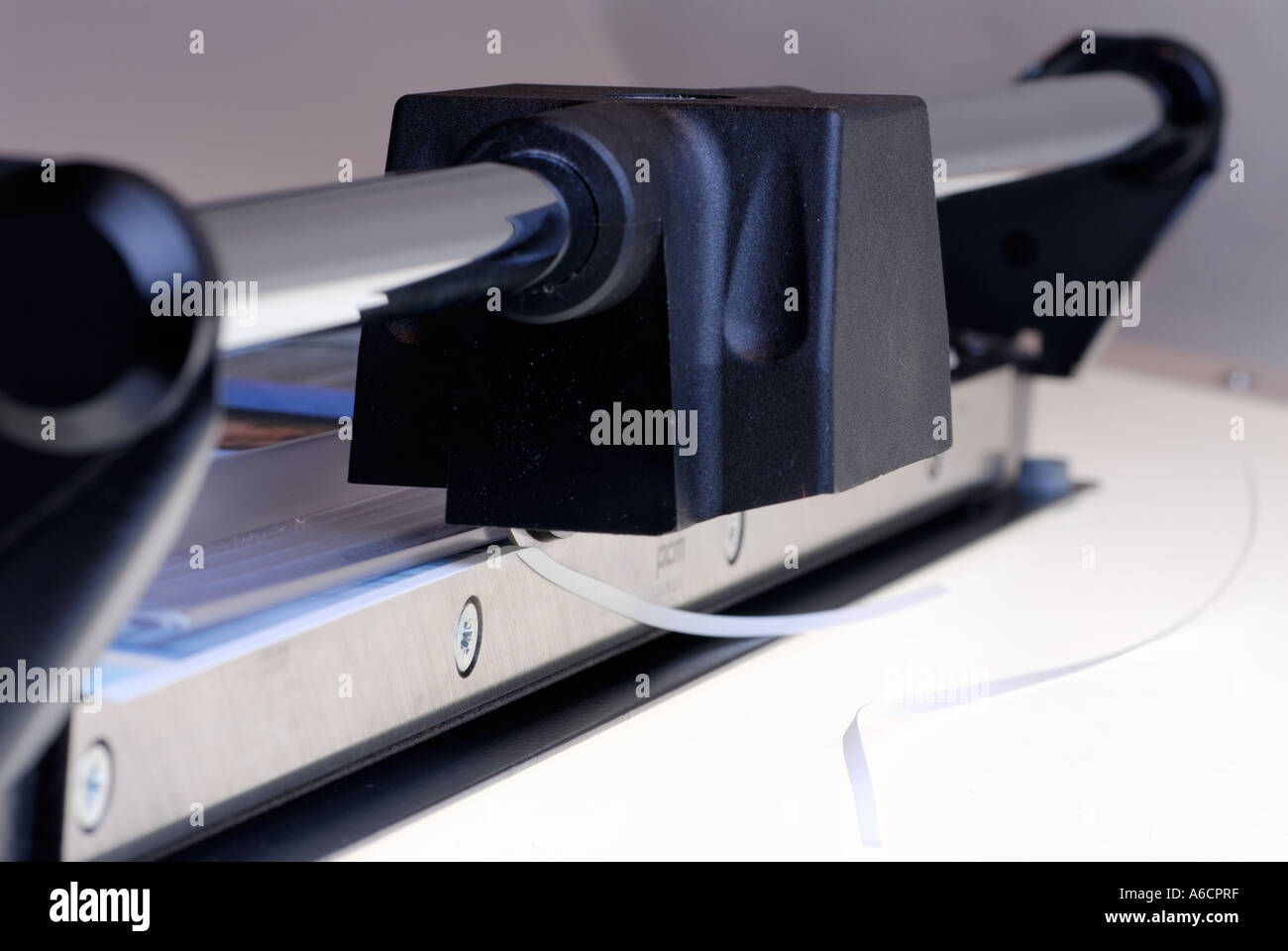 Rototrimmer or rotary trimmer cutting off the edge of a paper picture print for framing Stock Photo